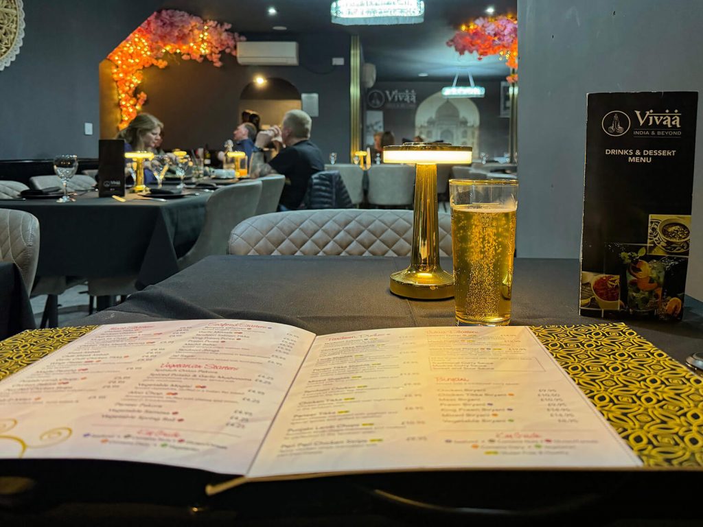 A menu and a cold refreshing beer in a smart modern Indian restaurant