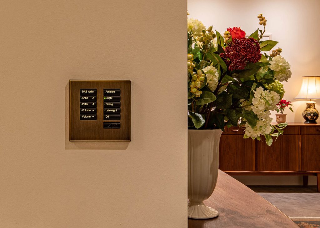 A Lutron seeTouch International keypad in antique brass with control of lighting scenes and audio